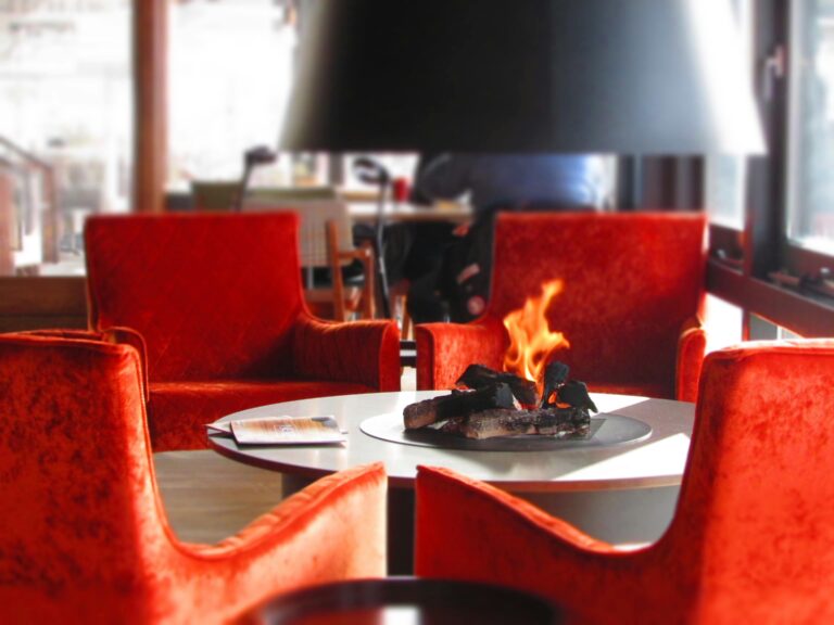 Home Luxurious dining space featuring a warm fireplace surrounded by contemporary chairs and elegant decor.